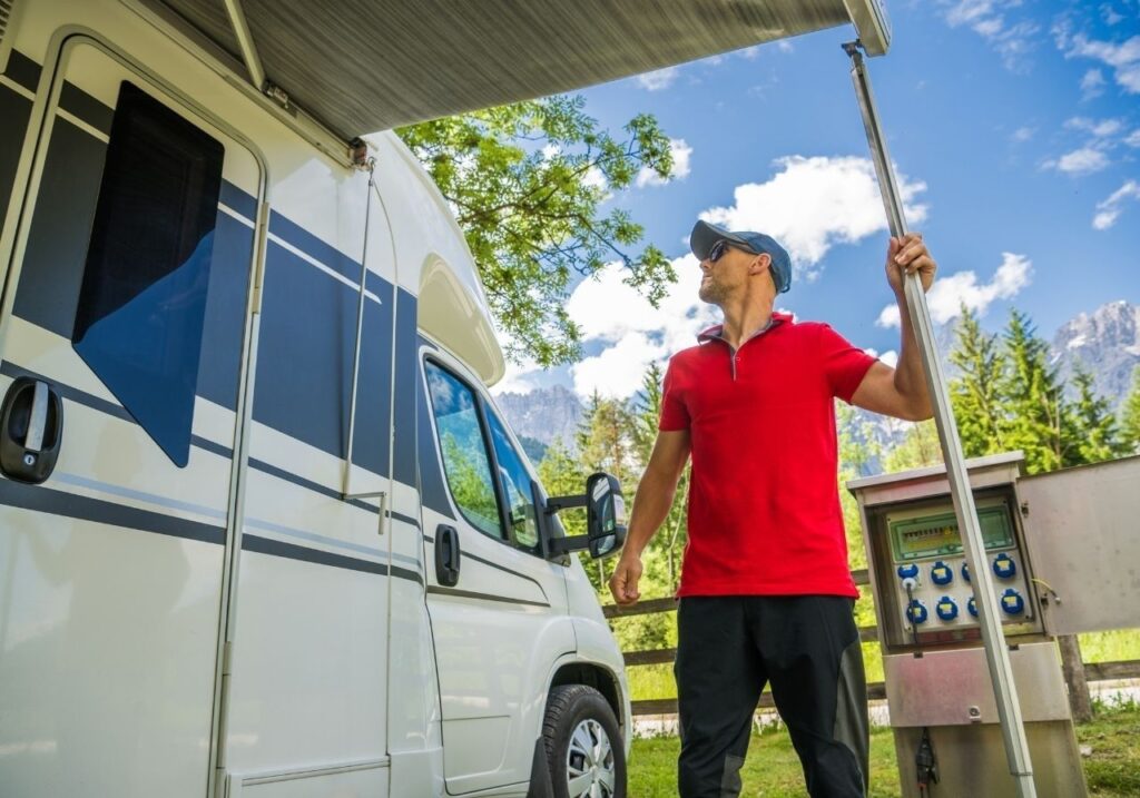 Certified RV technician inspecting awning damage on Class C motorhome