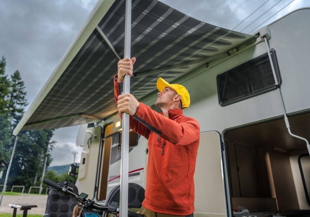 Close-up of torn RV awning fabric being replaced during mobile service