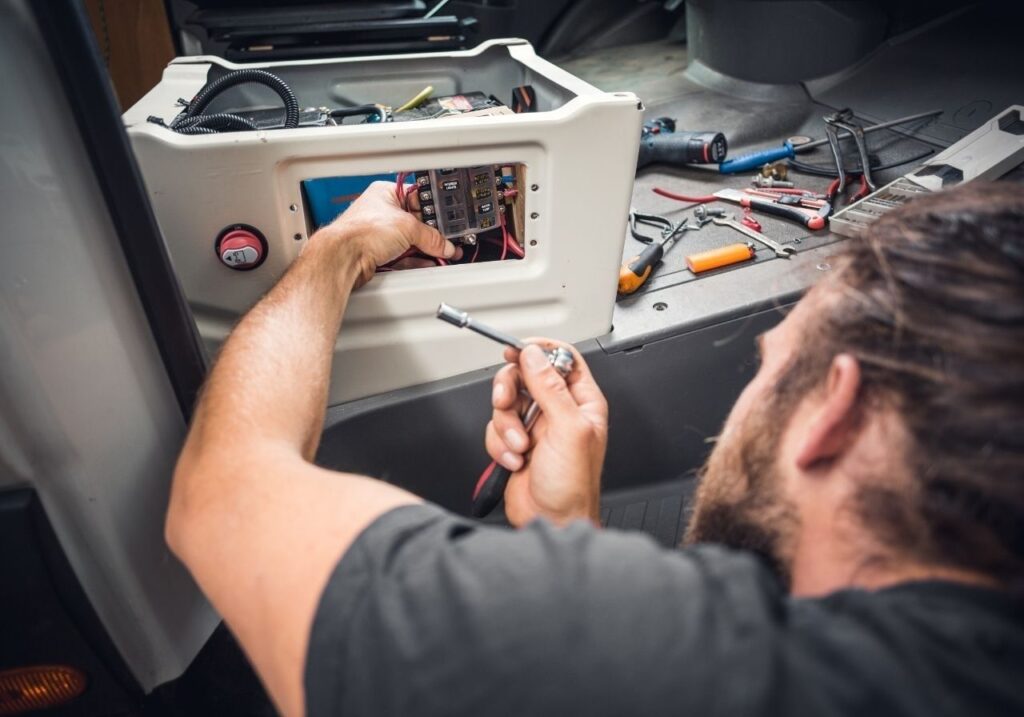 Technician working quickly with tools on-site at a campground with customer RV in background