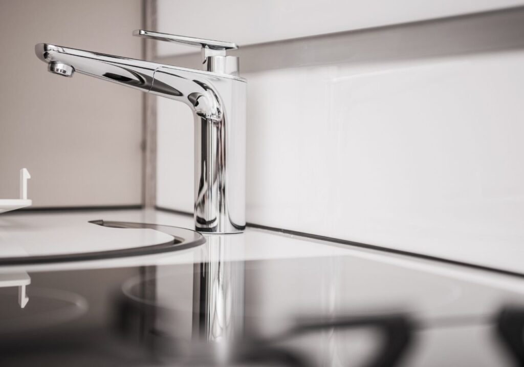 Close-up of leaking RV faucet being repaired with tools on-site