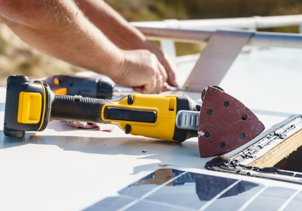 Close-up of RV roof sealant being applied to fix water leak on rubber roof