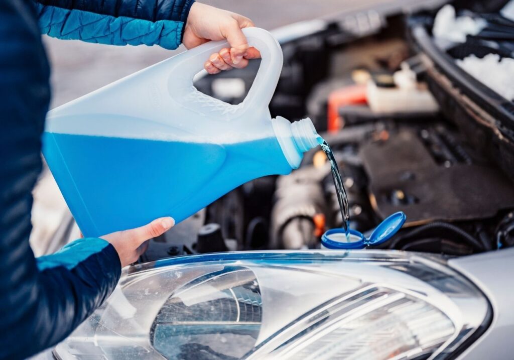 Close-up of antifreeze being poured into an RV system for winter protection